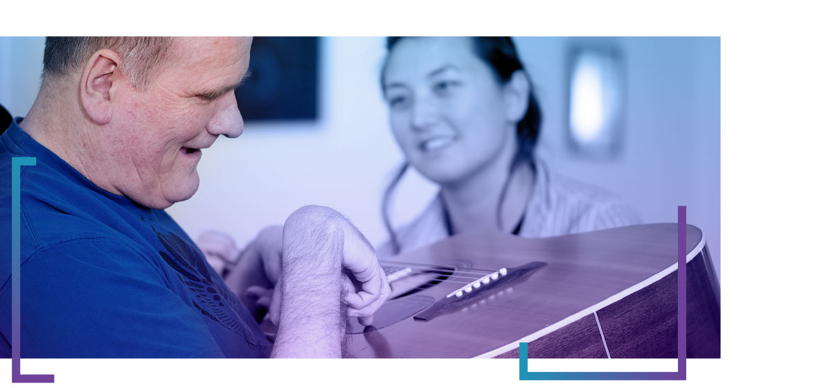 Image of client playing the guitar and having fun